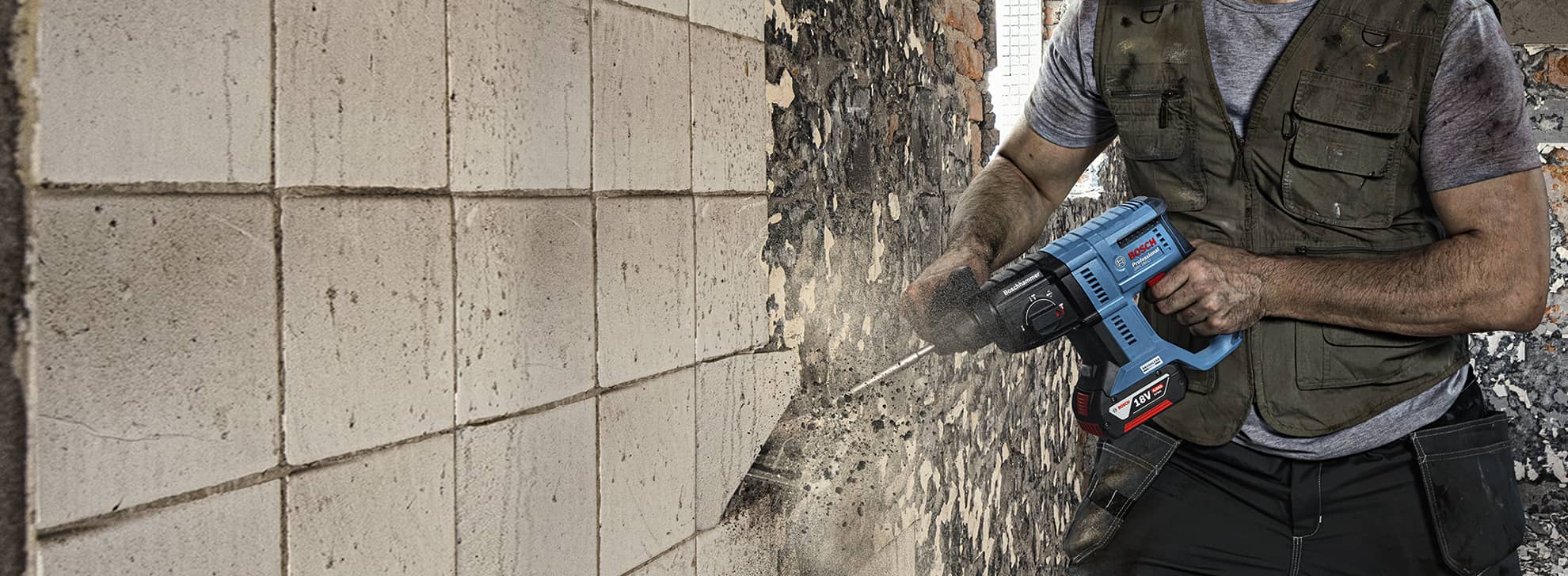 一名工匠在墙上使用蓝色博世专业钻头。