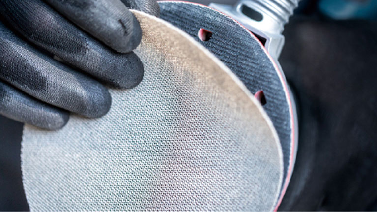 两只戴着黑手套的手握着一个磨盘。