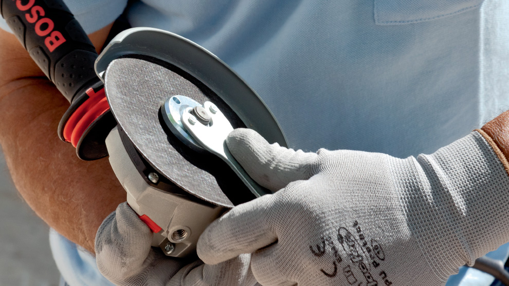 一个人手里拿着博世专业磨光机。