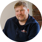 一个微笑的短发男人穿着蓝色毛衣。