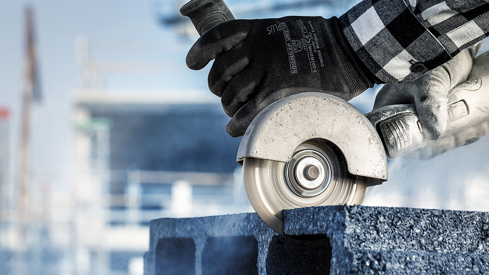 一个人正在用切割机切割灰色石头。