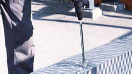 一名工匠在砖块上使用博世专业钻头。