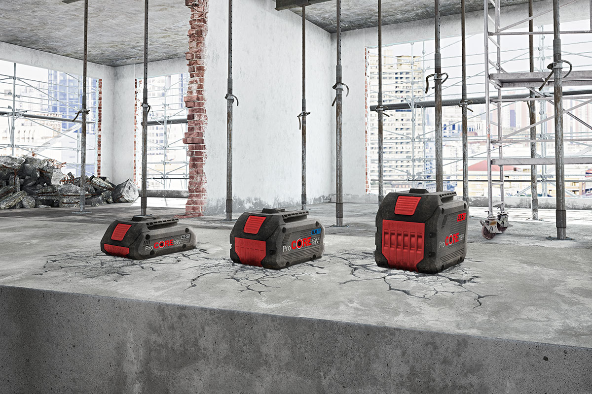 三个黑色博世专业电池放在一个破裂的混凝土地面上。